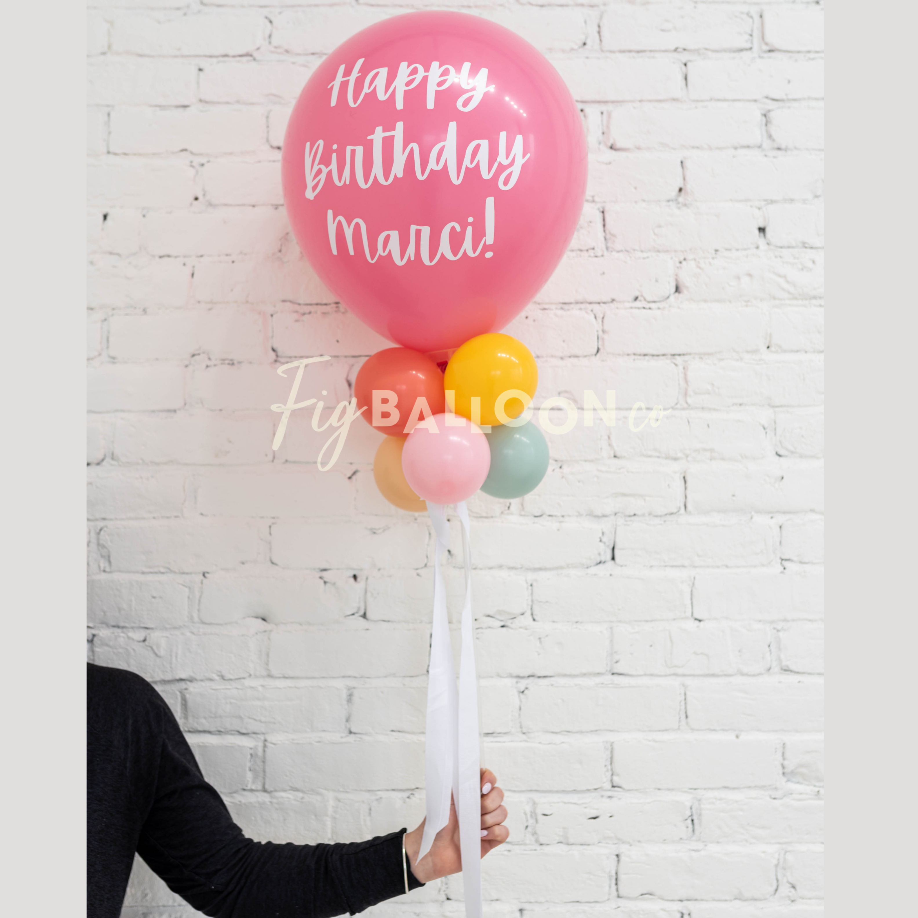 person holding pink balloon wand with a birthday wish