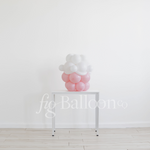 Decorative balloon display on a stand against a white wall with 'fig balloons' branding.