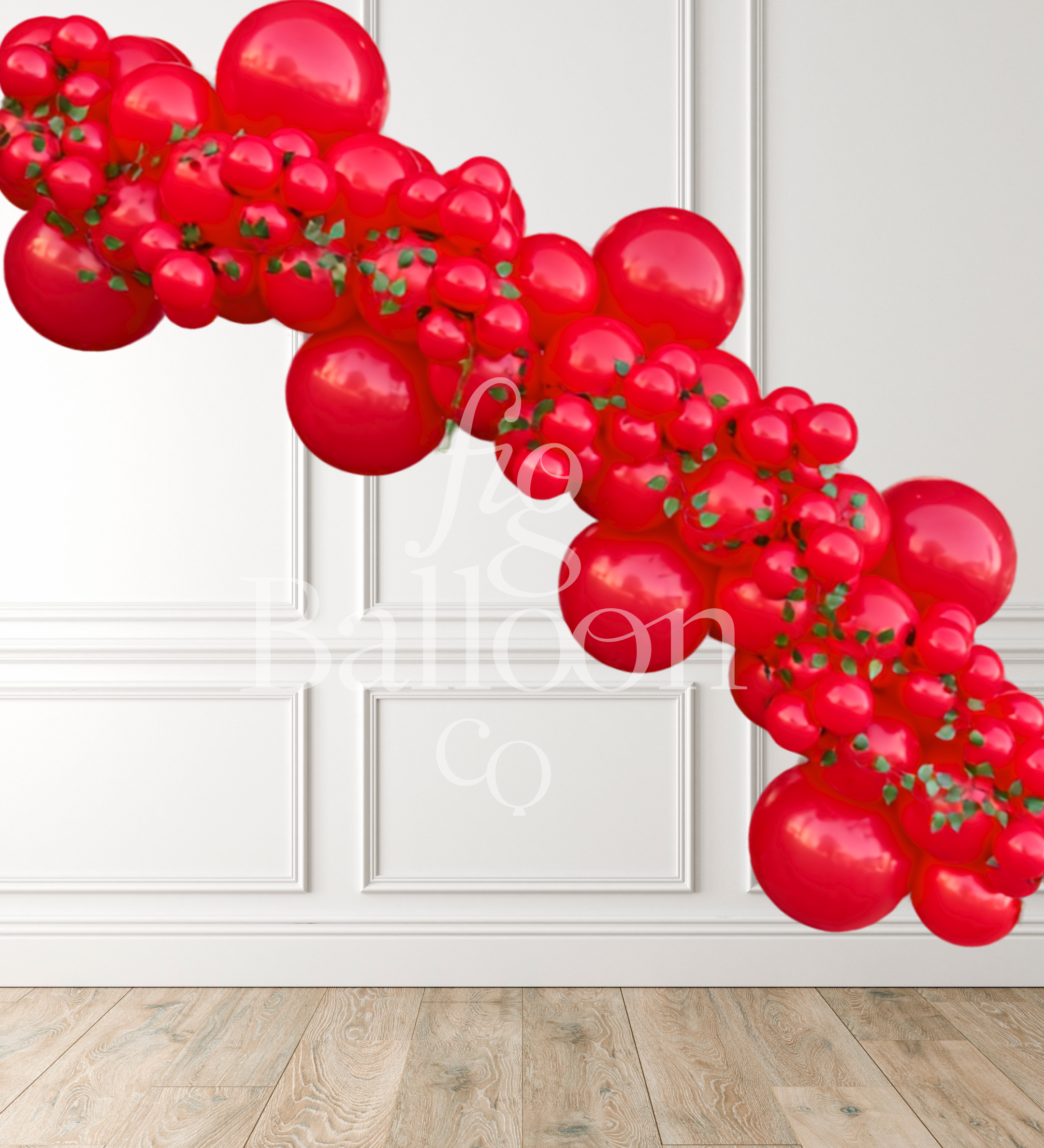 A red balloon garland made of glossy red latex balloons with small green leaf accents, displayed diagonally against a white paneled wall and light wood floor.
