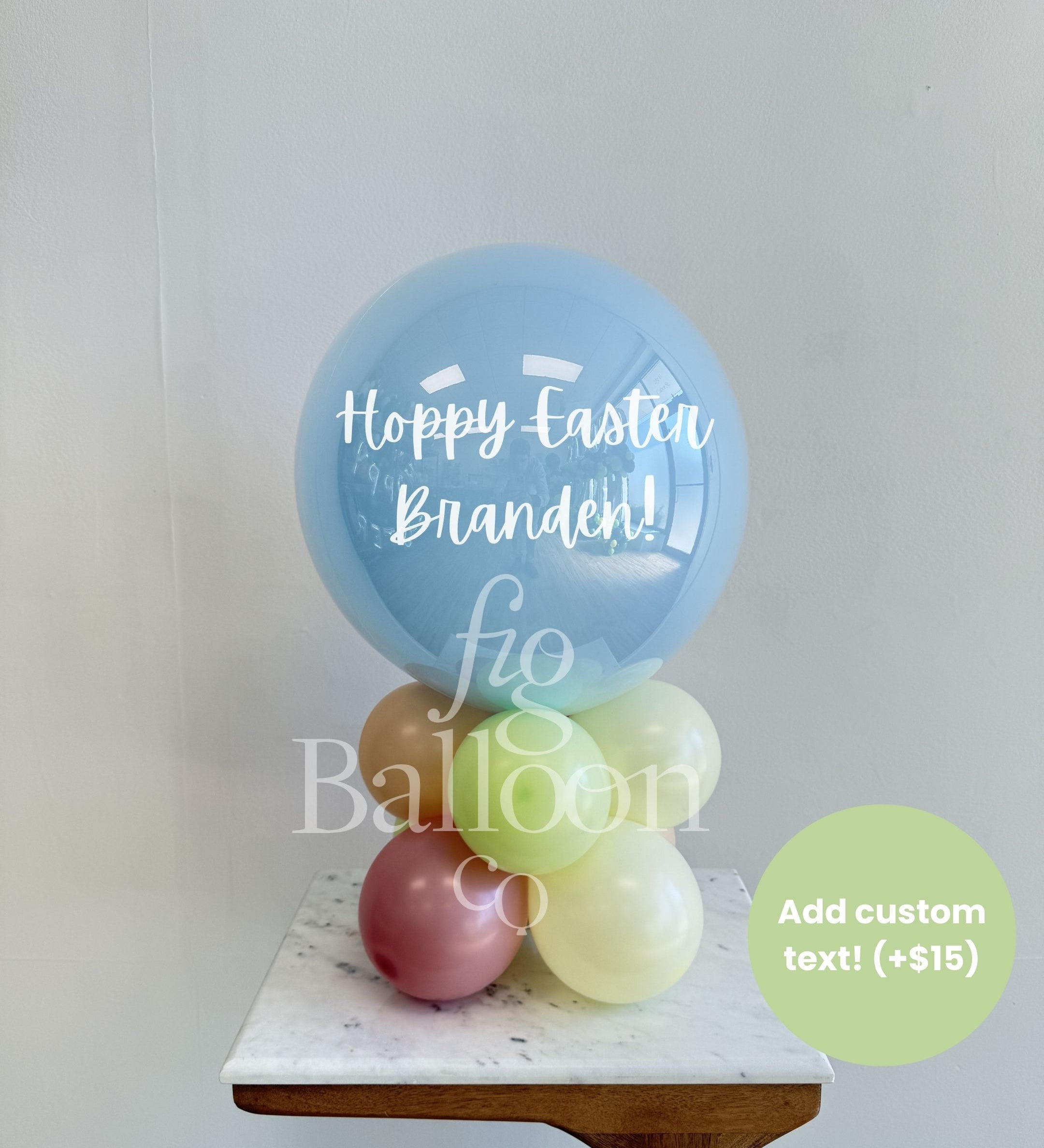 Stack of balloons with 'Happy Easter Branden!' text on a white surface, with a visible brand name.