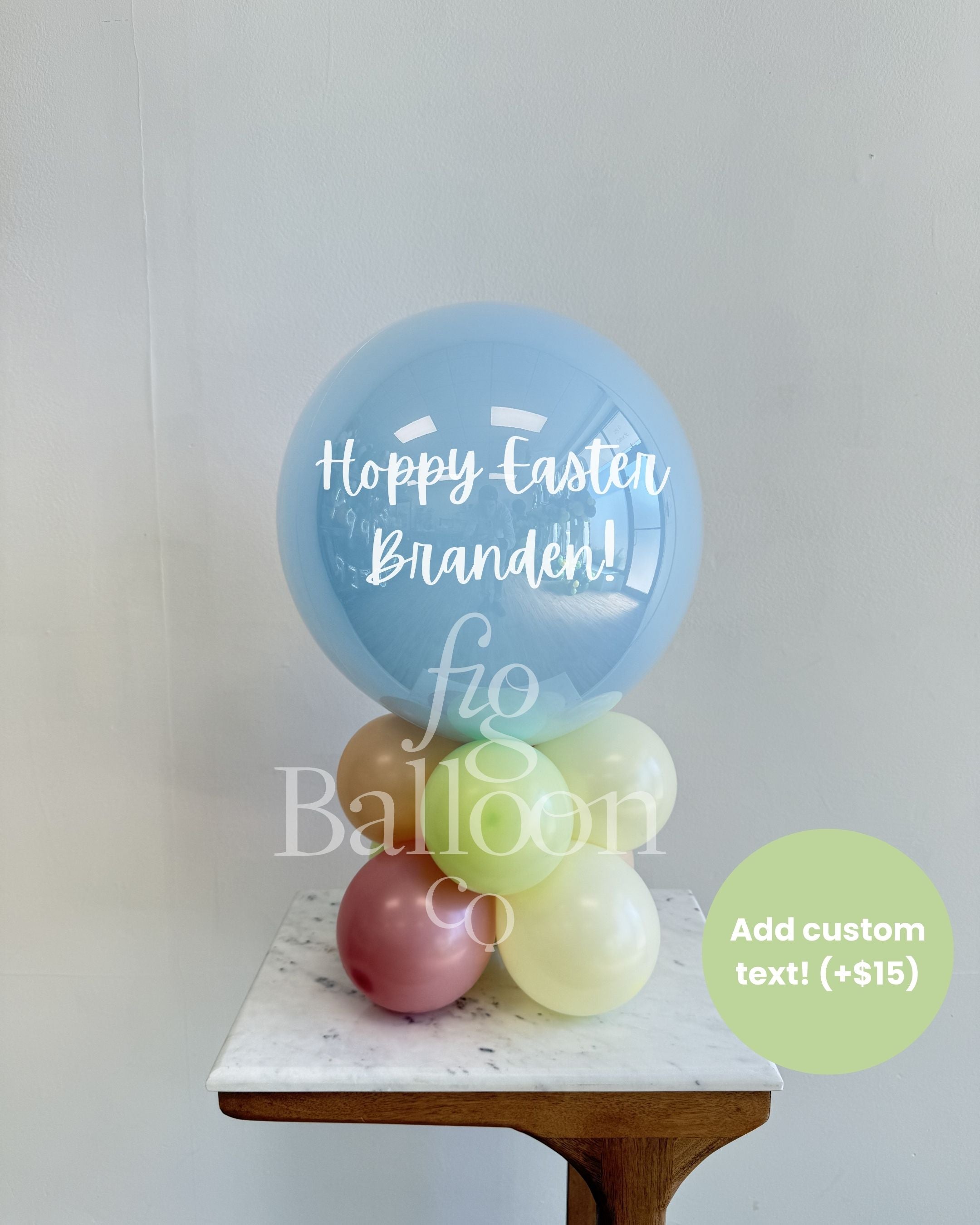 Stack of balloons with 'Happy Easter Branden!' text on a white surface, with a visible brand name.